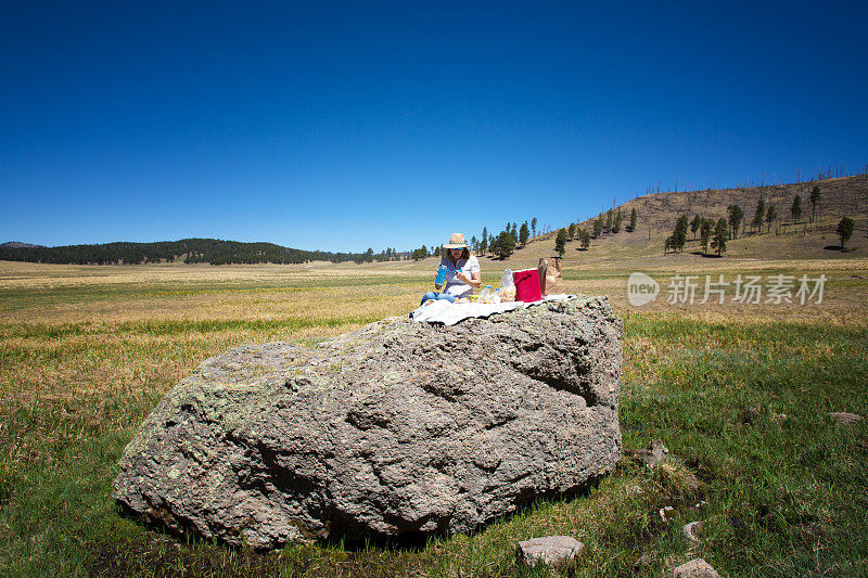 Valles Caldera国家保护区，NM:女人在岩石上野餐